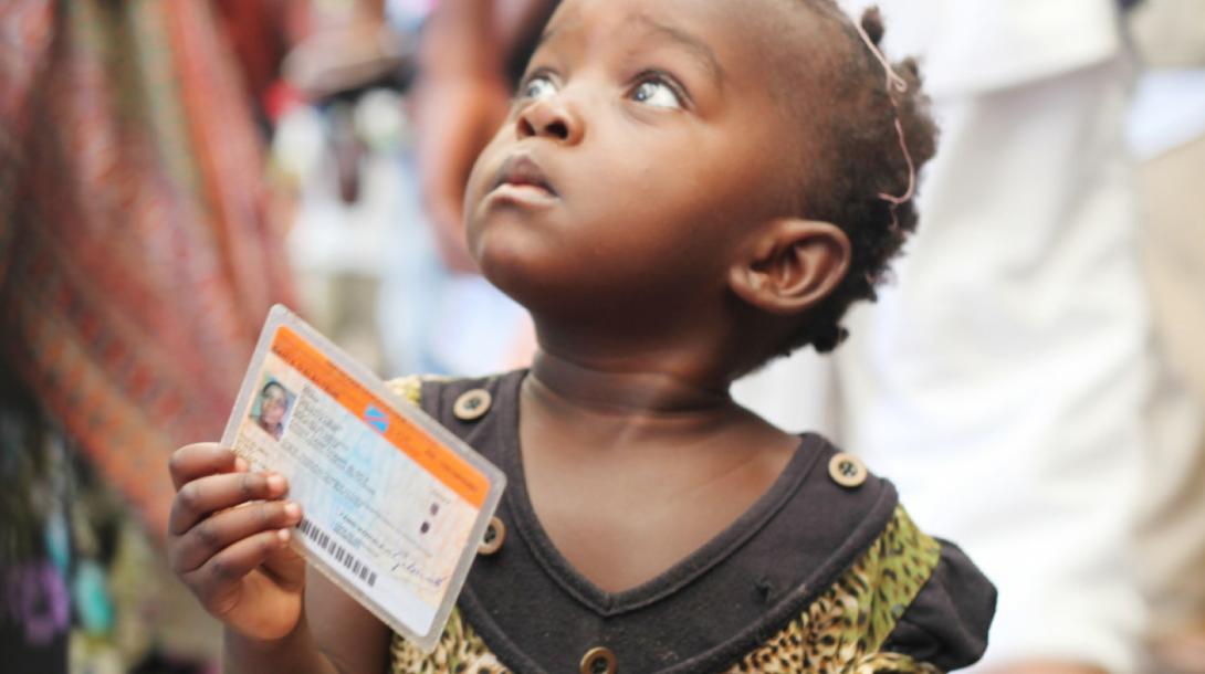 Crédits Photo: MONUSCO / Myriam Asmani. Une petite fille tenant une carte de vote lors des élections de 2011 en République démocratique du Congo (RDC).
